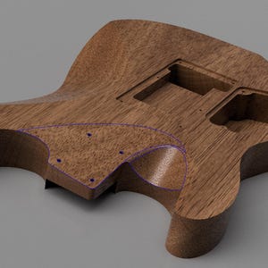 May include: A brown wooden electric guitar body featuring a prominent wood grain pattern, a contoured shape, and multiple recessed cavities for electronic components. The surface includes a defined area outlined in blue with small screw holes.