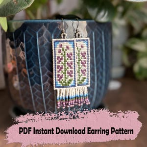 May include: Handmade beaded earrings with a floral pattern in purple, green, and blue. The earrings have a rectangular shape with a fringe of beads at the bottom. The text "PDF Instant Download Earring Pattern" is visible.