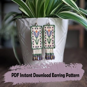 May include: Handmade beaded earrings with a floral design. The earrings feature a rectangular shape with a cream-colored background, green and purple accents, and a dangling fringe of beads. The text "PDF Instant Download Earring Pattern" is visible.