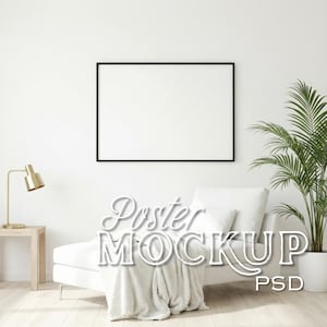 May include: A blank black framed poster mockup on a white wall above a white chaise lounge with a blanket. A gold desk lamp sits on a small wooden table. A potted plant is to the right. The text "Poster MOCKUP PSD" is overlaid.