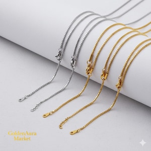 Puede incluir: Primer plano de varios collares delicados. Algunos son de color plateado, mientras que otros son de color dorado. Cada collar presenta una fina cadena con un cierre en el extremo. Los collares se muestran sobre un fondo blanco.