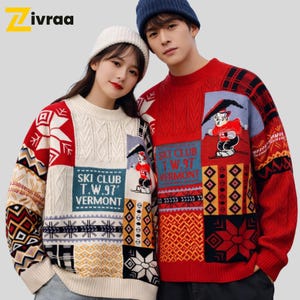 Puede incluir: Dos personas con suéteres de patchwork a juego. Uno es crema, el otro rojo. Ambos tienen un parche "SKI CLUB T.W.97 VERMONT" y un gráfico de esquiador de dibujos animados. Los suéteres tienen patrones geométricos y de copos de nieve. El logo "Zivraa" es visible.