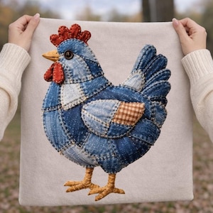 May include: A square off-white fabric panel featuring a decorative applique of a chicken crafted from various shades of blue denim fabric patches. The chicken has a red fabric comb and wattle, a yellow beak, a dark button eye, and tan fabric feet.