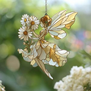 May include: Stained glass fairy holding daisies, with a chain for hanging. The fairy has a flowing dress and large, detailed wings. The color palette includes shades of cream, yellow, and brown, with white daisies.