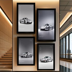May include: Four rectangular black-framed wall posters displayed on a light-colored wall. Each poster features a silver Porsche sports car on a gray background with white text identifying the specific model, including 918 Spyder and Carrera GT.