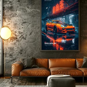 May include: A framed vertical wall art print featuring an orange Toyota Supra MK4 sports car parked on a wet city street at night. The image includes red neon Japanese text, the text TOKYO DIVISION, and TOYOTA SUPRA MK4 2JZ-GTE TWIN TURBO.