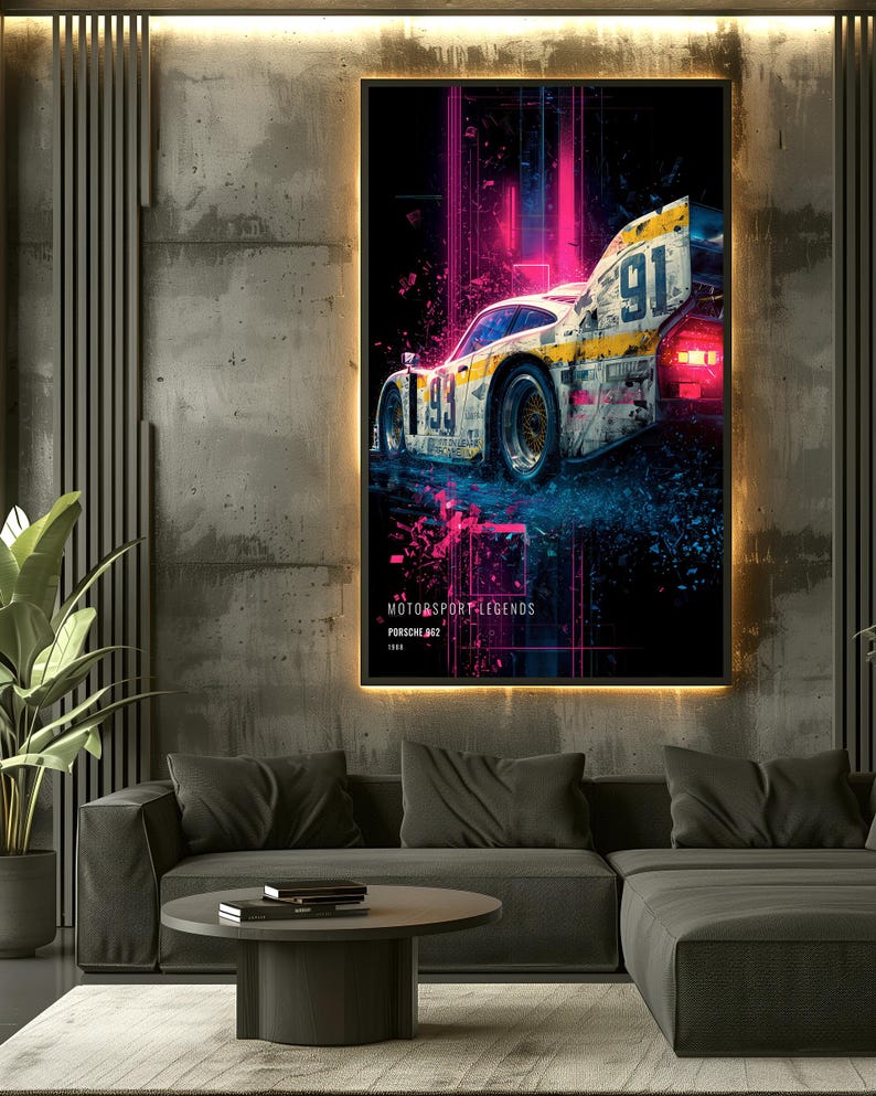 May include: A framed wall art print featuring a weathered Porsche 962 race car with the number 91, set against a dark background with vibrant pink and blue neon light streaks. The text reads MOTORSPORT LEGENDS, PORSCHE 962, and 1989.