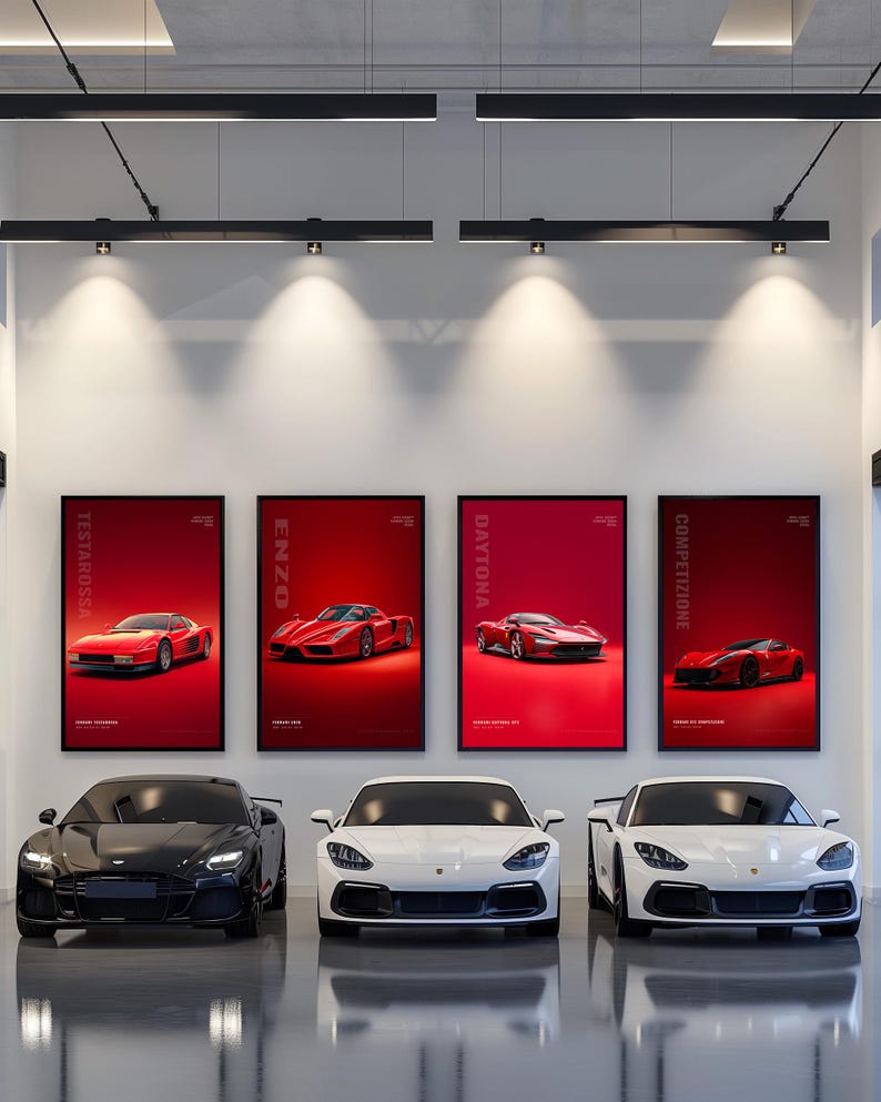 May include: Four framed vertical posters featuring red sports cars labeled Testarossa, Enzo, Daytona, and Competizione are displayed on a white wall above three luxury sports cars, one black and two white, parked on a polished gray floor.