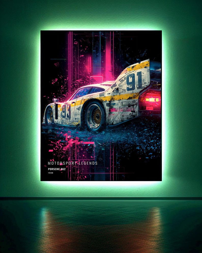 May include: A rectangular wall art piece featuring a Porsche 962 race car with the number 91 and 93 visible. The design includes vibrant pink and blue light streaks against a dark background, with the text MOTORSPORT LEGENDS PORSCHE 962 1988.