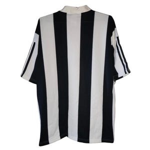May include: A short-sleeved, collared jersey with bold black and white vertical stripes. The jersey has a white collar and white sleeves with black stripes. The back of the jersey is visible, showcasing the striped pattern.