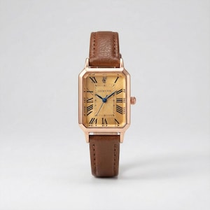 Puede incluir: Un reloj de pulsera rectangular dorado con una correa de cuero marrón. La esfera del reloj muestra números romanos y agujas azules. El reloj lleva la marca "LUCKY FOX".