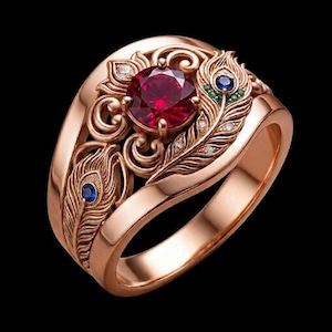 Puede incluir: Un anillo de oro rosa con una gran piedra roja de corte redondo en el centro, rodeada de intrincados detalles metálicos con forma de plumas de pavo real. El diseño incluye pequeños zafiros azules, piedras verdes y diminutos diamantes.