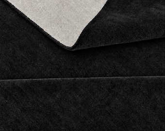 May include: A folded textile piece featuring a deep black, textured surface on the top layer and a contrasting light gray, woven fabric backing visible where the material is turned over, showcasing the dual-sided construction of the fabric.