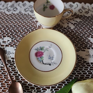 May include: A set of three ceramic mugs with a speckled, matte finish. The mugs are in shades of cream, light gray, and dark gray. Each mug has a simple, minimalist design and a rounded handle.