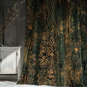 Op de afbeelding: Een zwart gordijn met een herhalend patroon van gouden en groene lijnen en cirkelvormige vormen. Het ontwerp lijkt op de textuur van boomschors. Het gordijn hangt voor een witte kast en een muur.