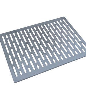 Könnte beinhalten: Ein rechteckiger, silberfarbener Metallrost mit einem Muster aus länglichen, gleichmäßig verteilten Schlitzen. Der Rost ist für Entwässerungs- oder Belüftungszwecke konzipiert und vor einem schlichten weißen Hintergrund platziert.