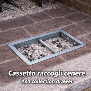 Könnte beinhalten: Eine rechteckige Metall-Ascheschublade, eingebaut in einen Ziegelstein-Kamin. Die Schublade ist in zwei Abschnitte unterteilt und mit Asche gefüllt. Der Text "Ash collection drawer" ist sichtbar.