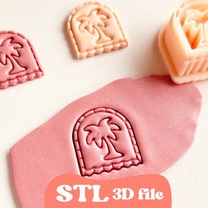 Puede incluir: Un conjunto de cortadores de galletas en forma de palmera de color rosa y melocotón y una impresión estampada en masa rosa. El texto "STL 3D file" está impreso en un círculo melocotón. Los cortadores tienen un borde festoneado.
