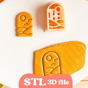 May include: An orange 3D cookie cutter and a cut-out cookie with a landscape design. The cutter has a rectangular shape with a sun and mountain design. The text "STL 3D file" is at the bottom.
