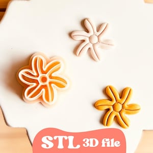 May include: Three flower-shaped objects in shades of orange and pink are displayed on a white surface. The objects have a six-petal design with a circular center. The text "STL 3D file" is visible in a pink circle.