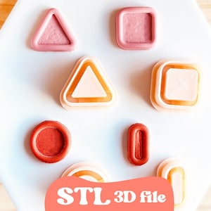 May include: A collection of geometric shapes in pink and orange hues, including triangles, squares, and circles. The shapes are displayed on a white surface. The text "STL 3D file" is visible at the bottom.