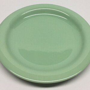 Puede incluir: Un plato de cerámica verde claro con un borde ligeramente elevado.