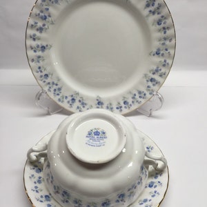 Op de afbeelding: Een theekopje en schotelset van Royal Albert bone china in het Forget-Me-Not patroon. Het kopje en de schotel hebben een delicaat blauw bloemenmotief met een gouden rand.