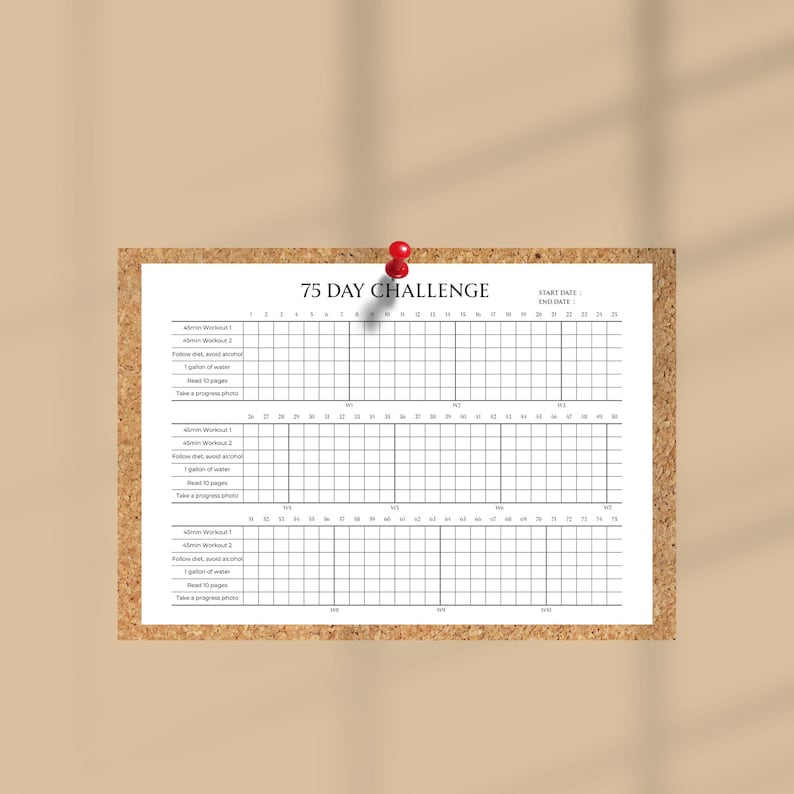 Puede incluir: Un rastreador blanco de 75 Day Challenge sujeto a un corcho con un imperdible rojo. El rastreador incluye espacios para tareas diarias y una cuadr&iacute;cula para marcar el progreso. El texto "75 DAY CHALLENGE" est&aacute; en la parte superior.