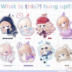 May include: A collection of eight anime-style character charms, each with a unique design and color scheme. The charms feature characters with large eyes and various outfits, with text labels including "REPUTATION," "LOVER," and "RED." The phrase "What is this?! hung up!!" is at the top.