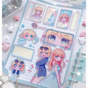 May include: A scrapbook page with anime-style illustrations of girls, featuring a grid background and decorative elements. The illustrations include characters with blonde hair, sunglasses, and various poses. Text includes "1987", "New", and "(happiness)".