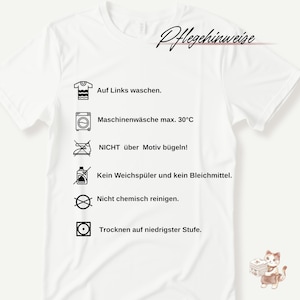 May include: White t-shirt with care instructions printed in black. Text includes "Auf Links waschen", "Maschinenw&auml;sche max. 30&deg;C", "NICHT &uuml;ber Motiv b&uuml;geln!", "Kein Weichsp&uuml;ler und kein Bleichmittel", "Nicht chemisch reinigen", and "Trocknen auf niedrigster Stufe."