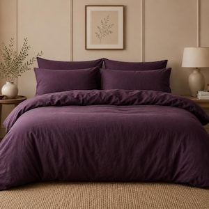 May include: A deep purple duvet cover set featuring a solid color design with a textured fabric appearance. The bedding ensemble includes a large duvet cover draped over a bed and two matching rectangular pillowcases positioned at the headboard.