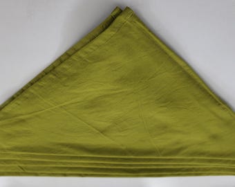 May include: A folded, olive-green cloth napkin, arranged in a triangle shape. The napkin is made of a soft, textured fabric and is folded into a fan shape at the base. The background is plain white.