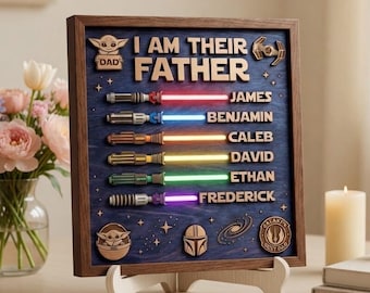 Op de afbeelding: Houten bord met de tekst "I AM THEIR FATHER" en gepersonaliseerde namen. Voorzien van lichtzwaardontwerpen met gekleurde stralen. Inclusief Star Wars-thema-iconen en een houten standaard.