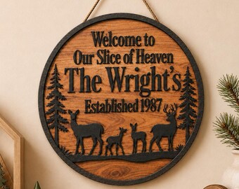 May include: A circular wooden wall sign featuring a natural wood grain center and a dark frame. The text reads Welcome to Our Slice of Heaven, The Wright's, and Established 1987. Below the text are black silhouettes of four deer and two pine trees.