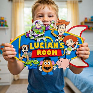 Può includere: Un cartello in legno blu, giallo e rosso con personaggi del film Toy Story. Il cartello recita "LUCIAN'S ROOM" in lettere gialle. I personaggi includono Buzz Lightyear, Woody e Jessie.