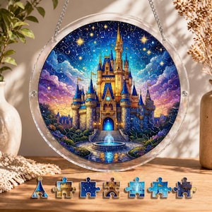 Könnte beinhalten: Ein rundes Puzzle mit einem farbenfrohen Schlossmotiv in Blau- und Goldtönen vor einem sternenklaren Nachthimmel. Das Puzzle wird in einem transparenten, kreisförmigen Rahmen präsentiert, mit einigen Puzzleteilen darunter.