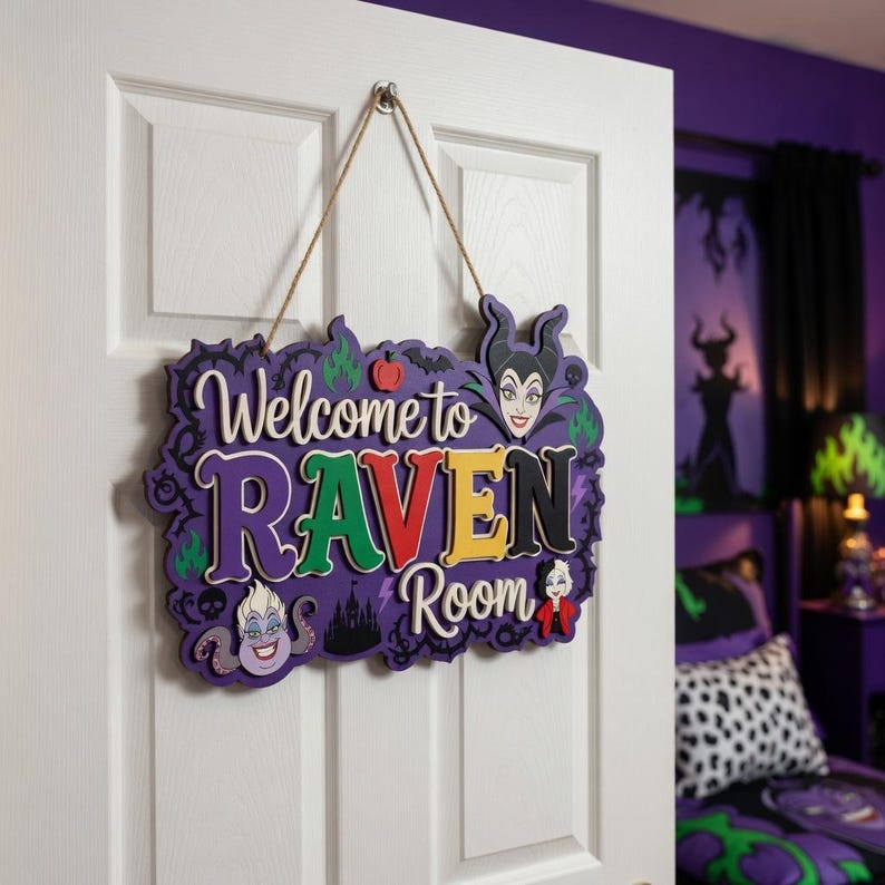 以下が含まれることがあります： 「Welcome to Raven Room」とカラフルな文字で書かれた紫と白の木製サイン。マレフィセントやアースラなど、ディズニーの悪役のイラストが描かれており、白いドアに掛けられています。