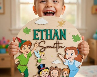 May include: A circular wooden sign featuring the name Ethan Smith in green and brown lettering. The design includes colorful illustrations of Peter Pan, Tinker Bell, Wendy, and the Lost Boys, accented with white clouds and green maple leaves.