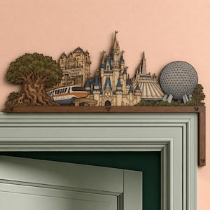 Pode incluir: Um ornamento de madeira para porta com um horizonte cortado a laser de marcos de parques temáticos, incluindo uma grande árvore, o Hollywood Tower Hotel, um monotrilho, um castelo, uma atração espacial e uma esfera geodésica.