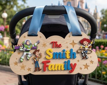 May include: A light-colored wooden sign shaped like a cloud, featuring the text The Smith Family in red, yellow, and blue. The sign includes cutouts of Buzz Lightyear, Woody, and Jessie, along with star and sheriff badge engravings, suspended by light blue ribbons.
