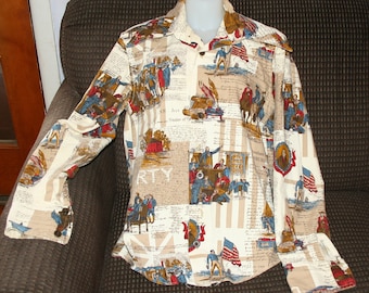 May include: A long-sleeved shirt with a patriotic print. The shirt features a cream-colored background with illustrations of historical figures, flags, and text. The design includes red, blue, and brown accents. The shirt has a button-down front and cuffs.
