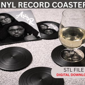 Könnte beinhalten: Schwarze Vinyl-Schallplatten-Untersetzer mit einem Foto eines Paares. Ein Weinglas mit klarer Flüssigkeit steht auf einem Untersetzer. Das Bild enthält auch eine Schallplatte und den Text "STL FILE DIGITAL DOWNLOAD".