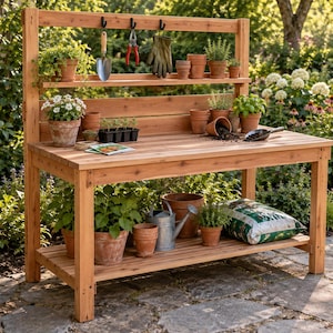 Può includere: Un banco da giardinaggio in legno con finitura naturale, dotato di un'ampia superficie di lavoro, un ripiano inferiore e un ripiano superiore con tre ganci neri. Il banco è organizzato con vari vasi in terracotta, attrezzi e piante.