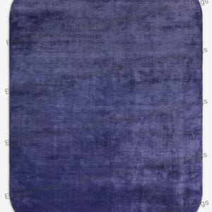 May include: A rectangular indigo rug with rounded corners. The rug has a soft, textured appearance, with subtle colour variations creating visual depth. The design is simple and elegant, suitable for various interior styles. The rug is a deep shade of blue.