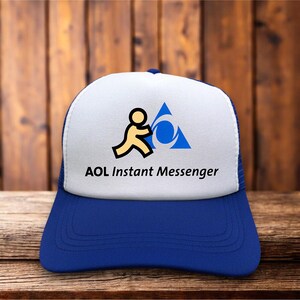 Peut inclure: Une casquette de type trucker bleue et blanche arborant le logo AOL Instant Messenger sur le devant. Le logo présente une icône de personnage jaune à côté d'un triangle bleu avec une découpe circulaire, avec le texte AOL Instant Messenger.