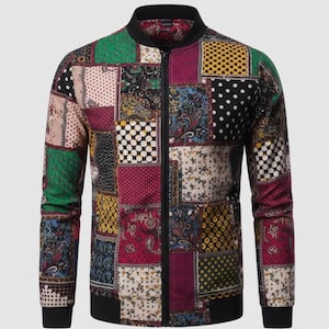 Może przedstawiać: Kurtka bomberka z patchworku z czarnym kołnierzem, mankietami i dołem. Kurtka posiada różnorodne kwadraty we wzory w kolorach takich jak zielony, czerwony, żółty i czarny. Kurtka posiada zamek błyskawiczny na całej długości.