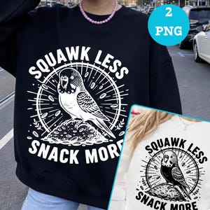 Könnte beinhalten: Schwarzes Sweatshirt mit einem weißen Grafikdesign einer Wellensittich-Illustration, umgeben von einem Kreis. Der Text "SQUAWK LESS" und "SNACK MORE" befindet sich über und unter dem Vogel.