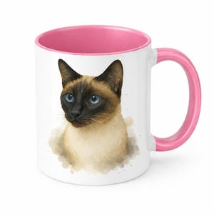 May include: White ceramic mug with a pink interior and handle. The mug features a watercolor illustration of a Siamese cat with blue eyes and a brown and black face. The cat is set against a light brown watercolor wash.
