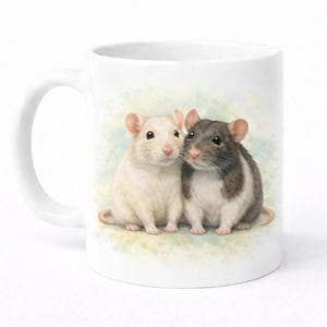 May include: White ceramic mug with a watercolour illustration of two friendly rats. One rat is white, the other is grey and white. The background has a soft, watercolour effect in shades of green and blue.